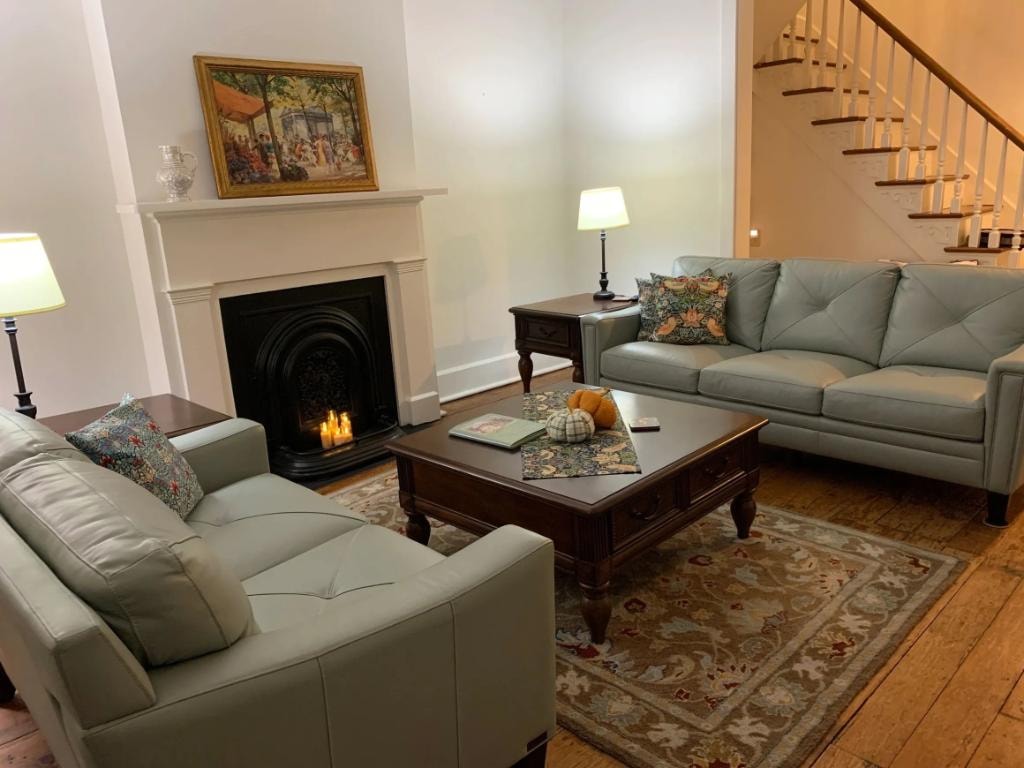 Madison Manor II living room with sage sofas and lit fireplace